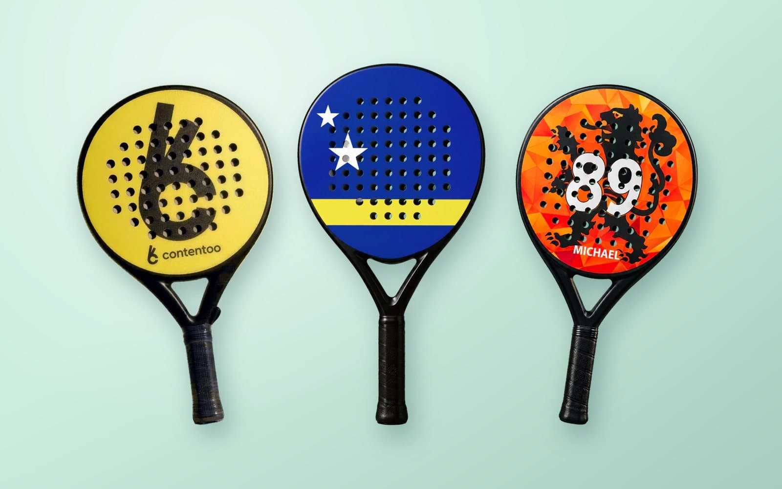 Drie custom padel rackets in geel, blauw en oranje, op een mintgroene achtergrond